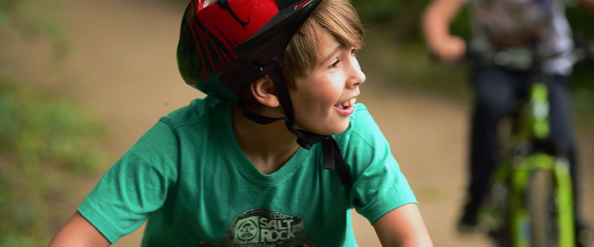 A young person smiling while cycling.