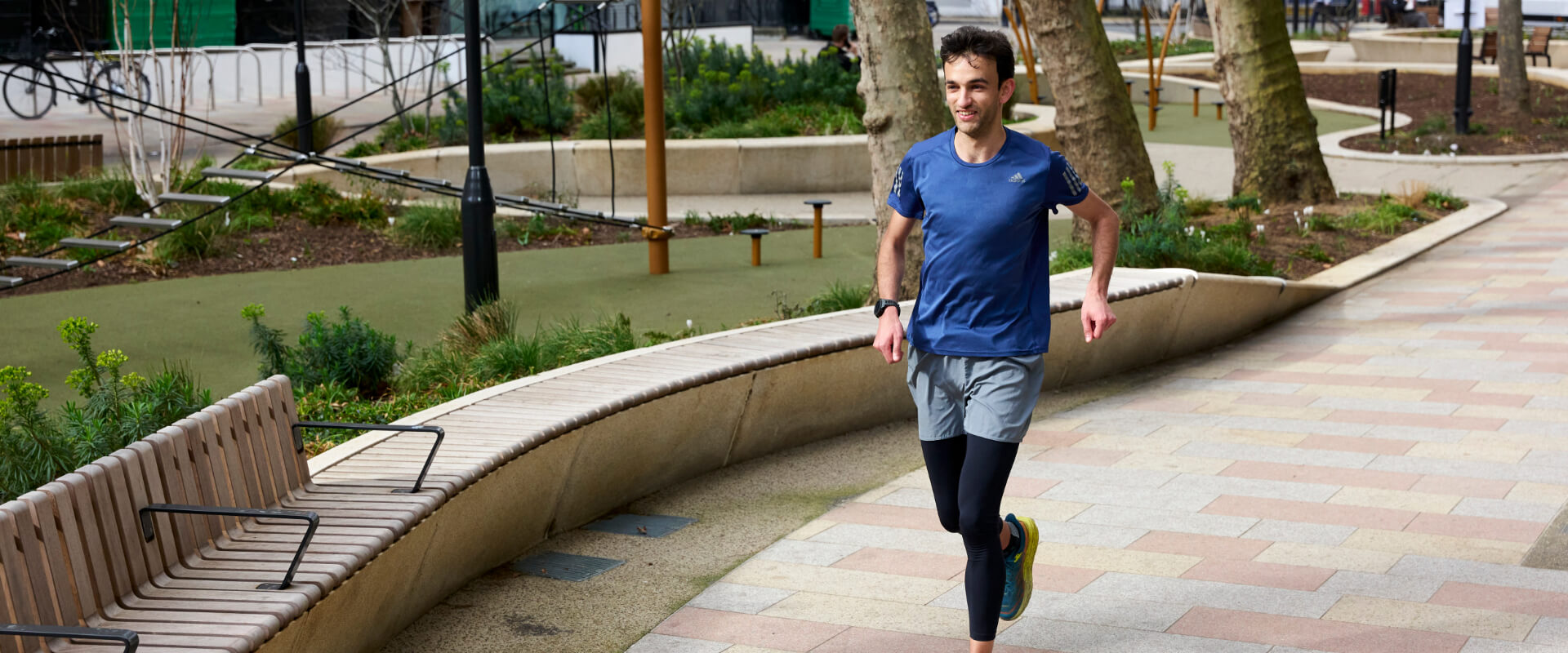 A person running on a path through a park.