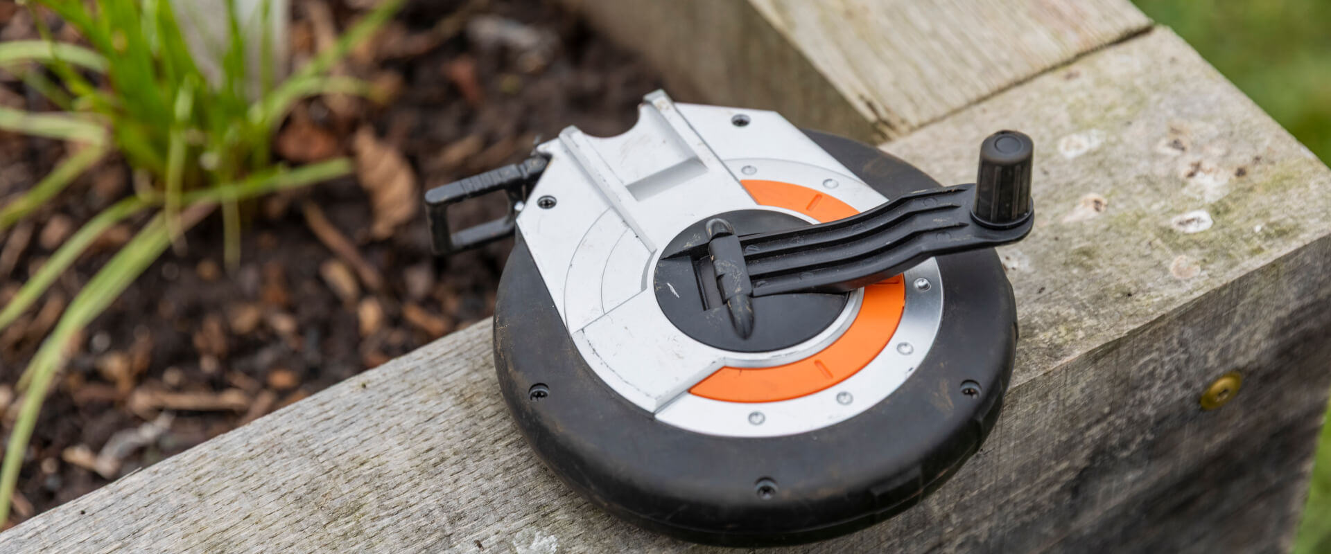 A measuring tape on the edge of a raised planting bed.