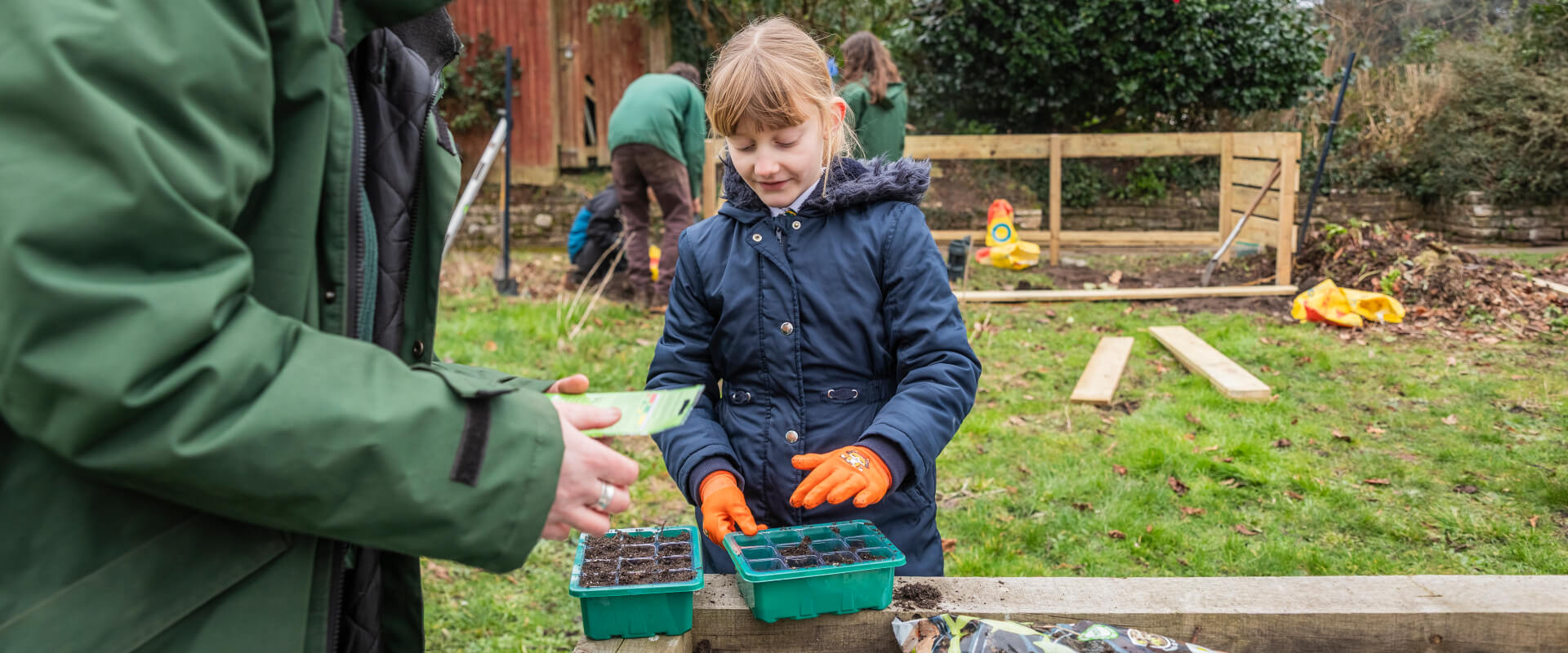 A young child volunteer planting seeds.