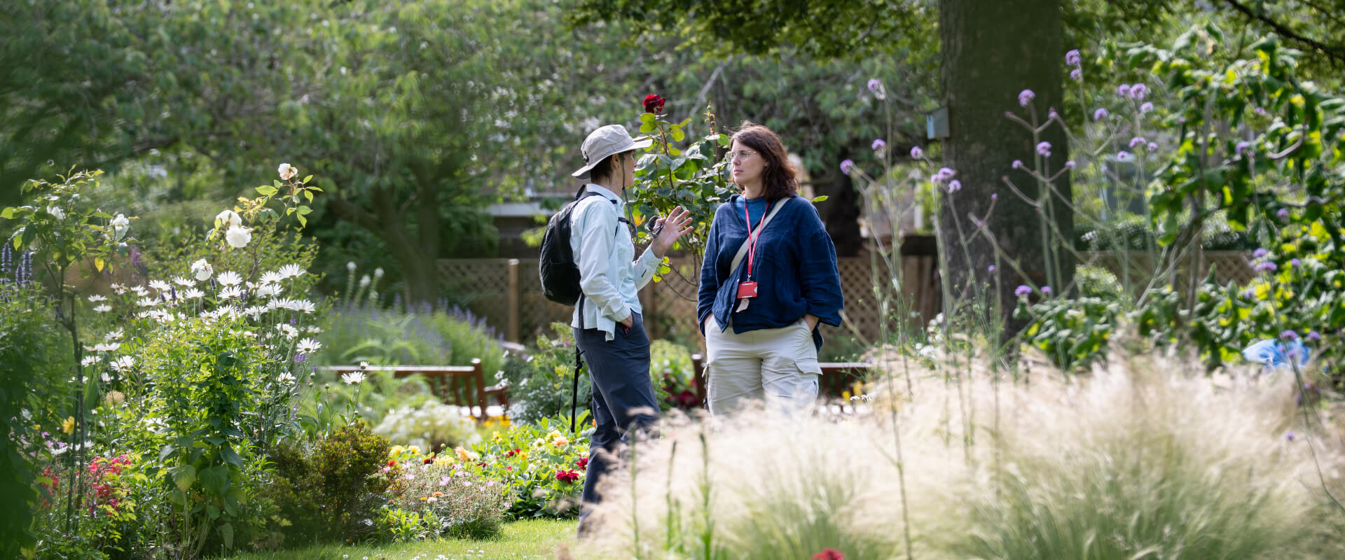 Two people conversing in the middle of a flower garden.