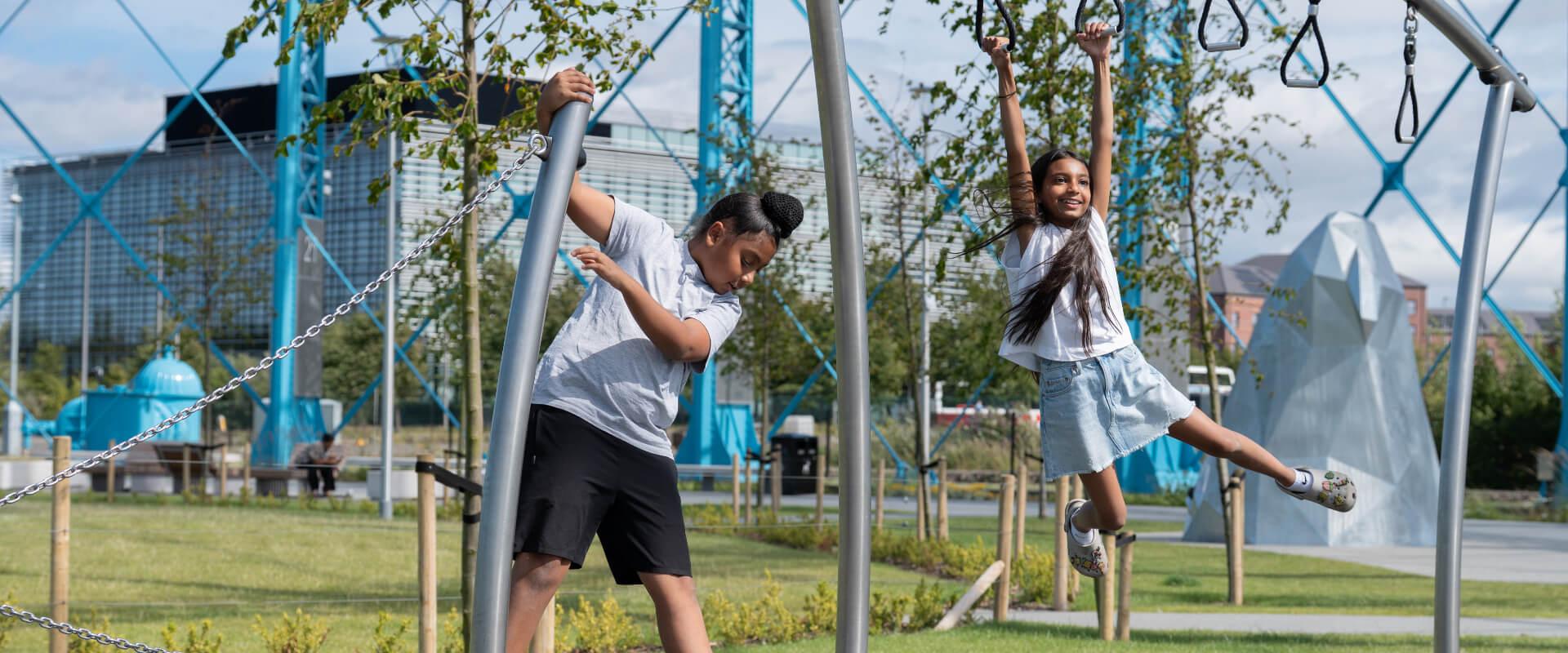 Two young people playing in a play area.