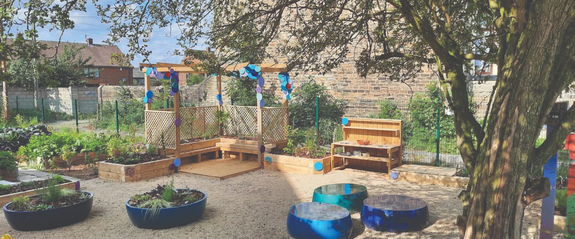 A community garden with some wooden furniture, planters and other decorations