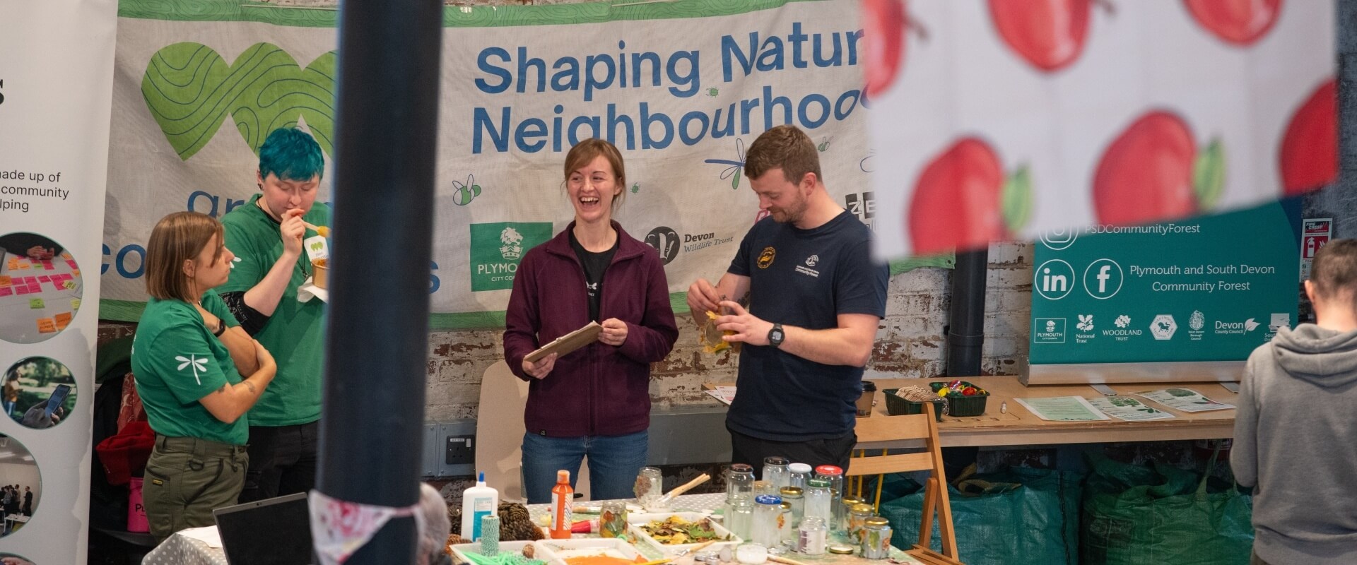 A team of people standing behind an arts and craft table at market stall.
