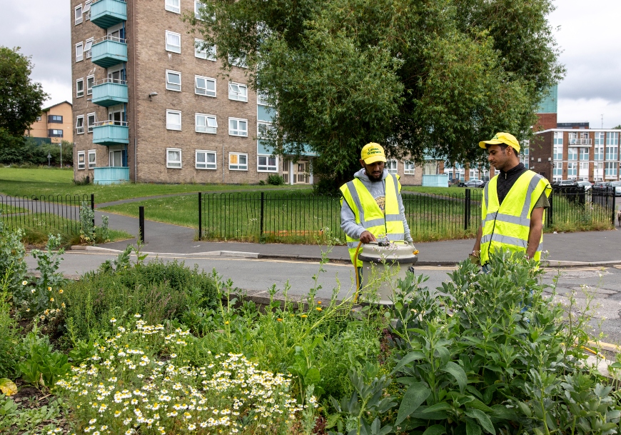 Two men in high-vis yellow tend to Mafwa Theatre's vegetable growing area in Lincoln Green, Leeds.